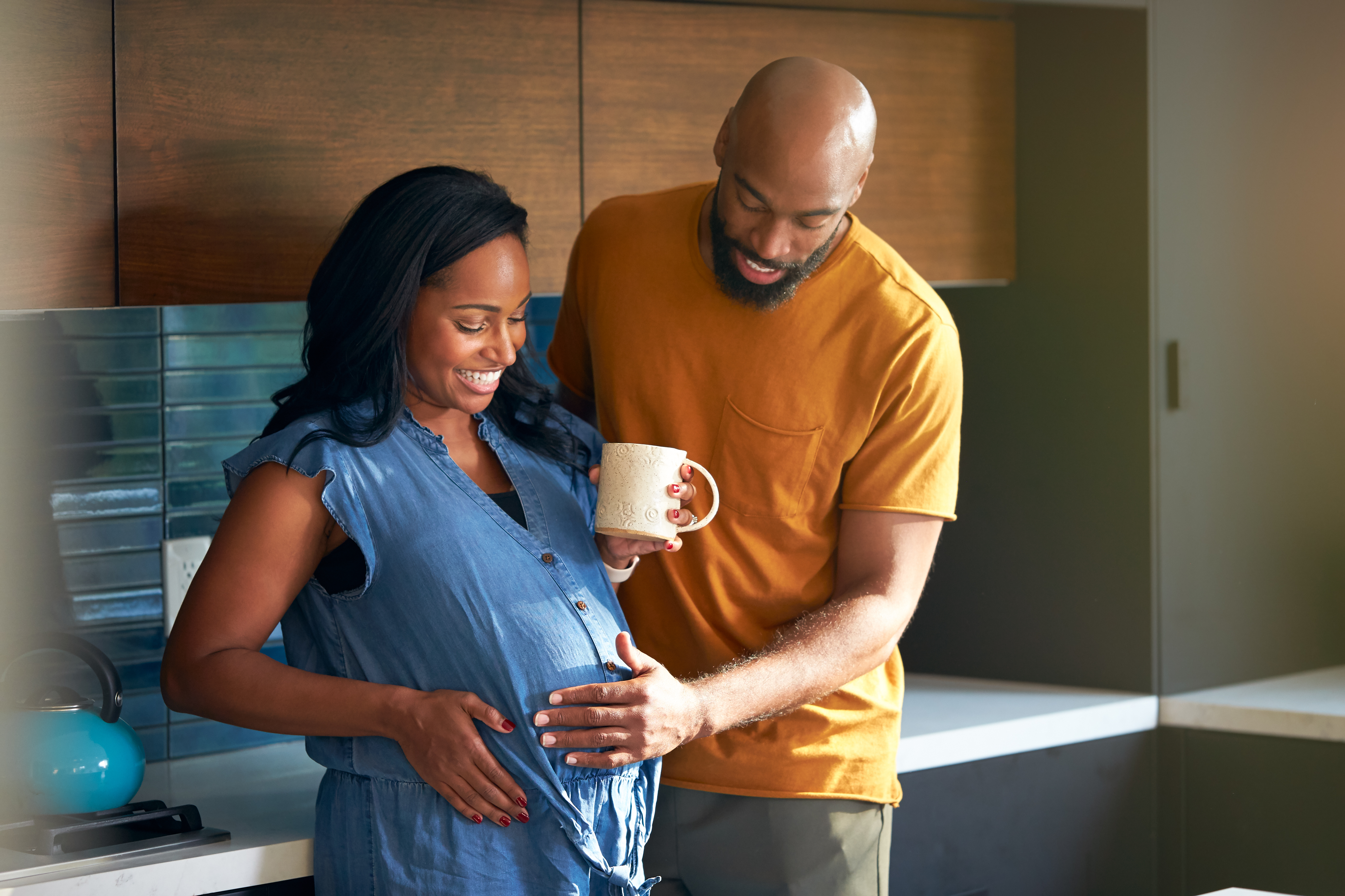 Loving,African,American,Husband,With,Pregnant,Wife,At,Home,In